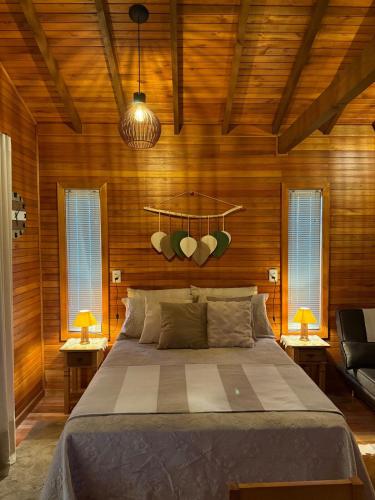 a bedroom with a bed and two lamps and windows at Sítio Brisa da Serra Conforto e Tranquilidade in Lauro Müller
