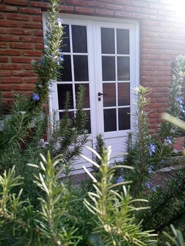a white front door of a house with plants at La Ricarda in Gualeguaychú