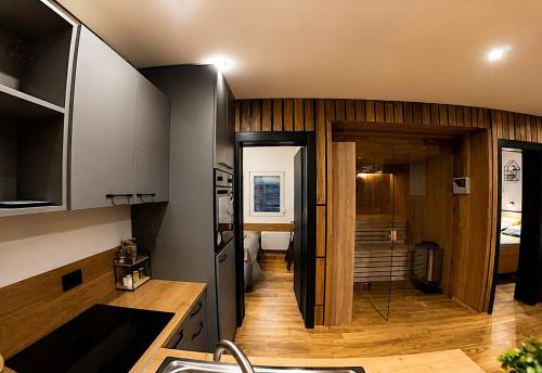 a kitchen with a sink and a room with a bed at Panorama House in Bartolovci