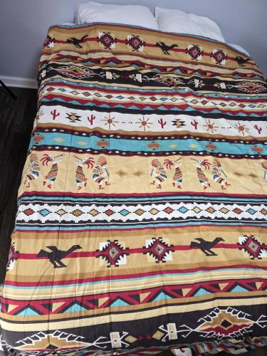 a bed with a colorful blanket on top of it at Lee motel in Nashville