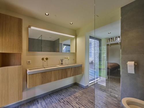 a bathroom with a sink and a mirror at De Muldershof in Vriezenveen