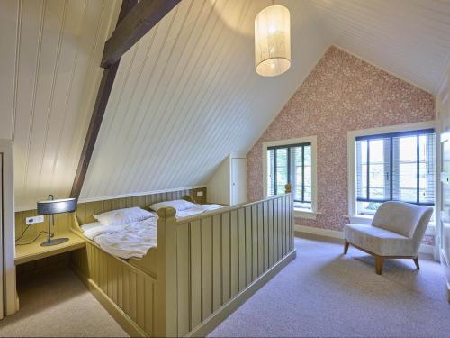 a bedroom with a bed and a chair in a attic at De Muldershof in Vriezenveen
