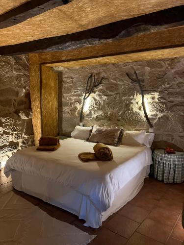 a bedroom with a bed with two hats on it at Quinta da Eira do Prado in Carvalho
