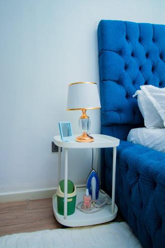 a table with a lamp on it next to a bed at Beryl's Haven in Marimbeti