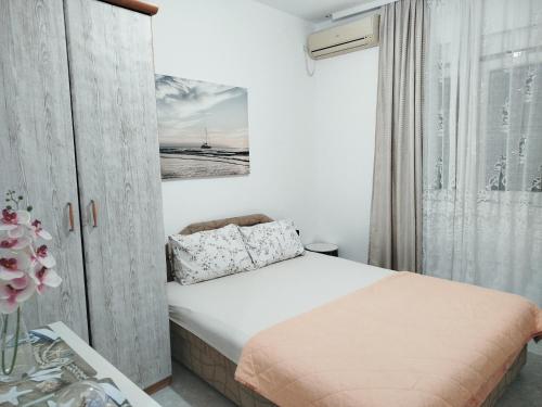 a small bedroom with a bed and a window at Pejovic Guest House in Sutomore