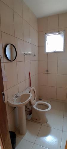 a bathroom with a toilet and a sink at Hotel Reflexos in Santa Juliana