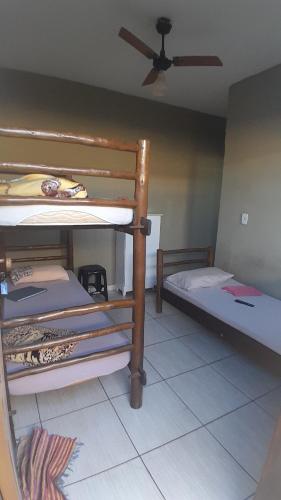 a room with two bunk beds and a ceiling fan at Hotel Reflexos in Santa Juliana