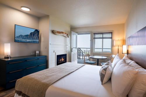 a bedroom with a large bed with a fireplace at Manzanita Oceanfront Inn in Manzanita
