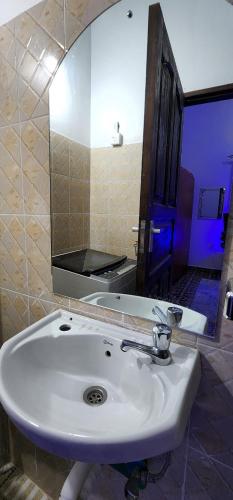 a bathroom with a white sink and a mirror at Charlie's Place Watamu in Watamu