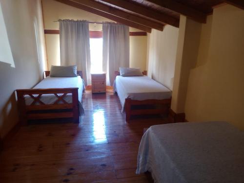 a room with two beds and a window at La cabaña de ines in El Bolsón