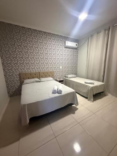 a bedroom with two beds and two slippers on them at Apto Serras Gerais 2 in Dianópolis
