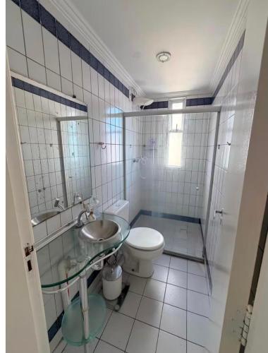 a bathroom with a toilet and a sink and a mirror at Apto amplo e confortável in Aracaju
