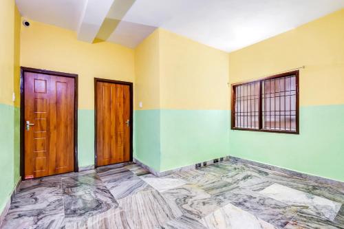 an empty room with two doors and a tile floor at OYO 80514 Moody Moon in Bārang