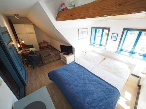 a bedroom with a bed with a blue blanket at Hansen-Hof-Wohnung-2 in Tinnum