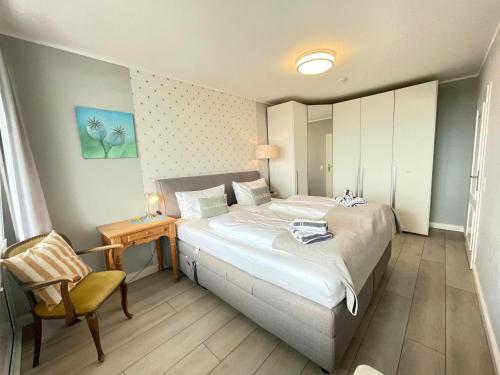 a bedroom with a large bed and a chair at Ferienwohnung-Hansen in Westerland