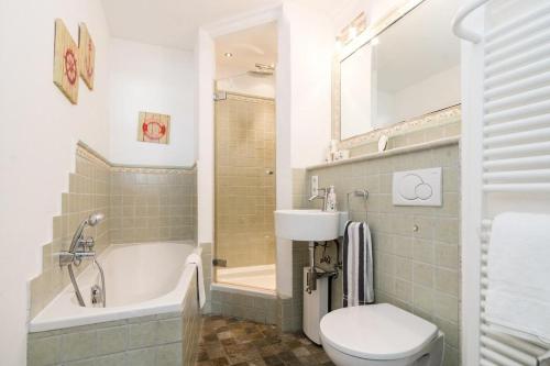a bathroom with a toilet and a tub and a sink at Ferienwohnung-Hansen in Westerland