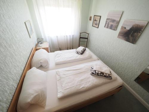 two beds in a room with white sheets at Appartement-152 in Westerland