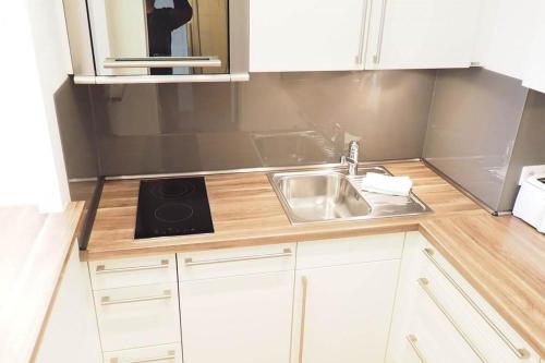 a kitchen with white cabinets and a sink at Appartement-155 in Westerland