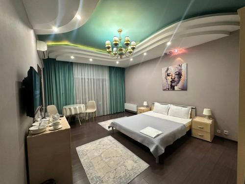 a bedroom with a large bed and a chandelier at Dostyq in Astana