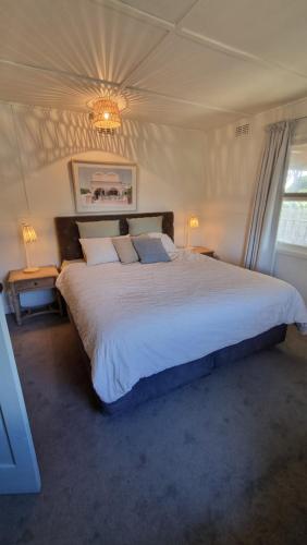 a bedroom with a large bed and a chandelier at The waterfront retreat in Lock Sport