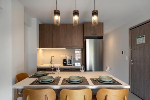 a kitchen with a table with plates and wine glasses at AKSQUARED Premium Vacation Apartments in Paralia Dionysiou