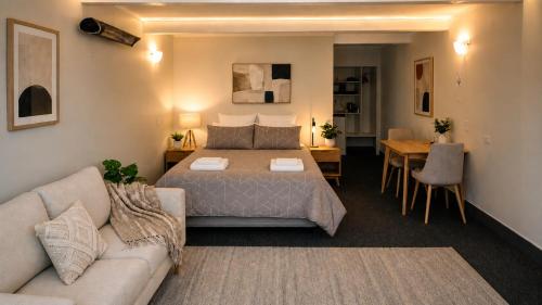 a bedroom with a bed and a couch and a table at The Cave Motel in Levin
