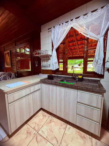 a kitchen with a sink and a window at Casa do Zeca Morretes in Morretes