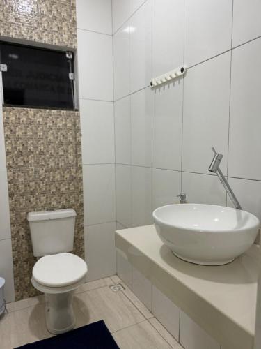a bathroom with a white sink and a toilet at Apt Serras Gerais Superior in Dianópolis