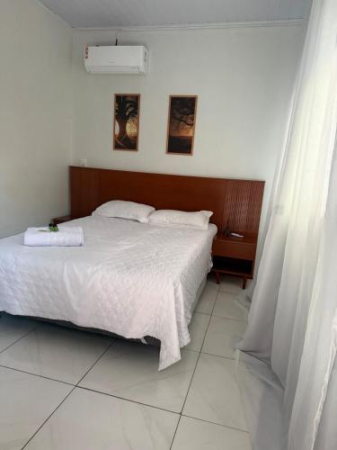 a bedroom with a large bed with white sheets at Apt Serras Gerais Superior in Dianópolis