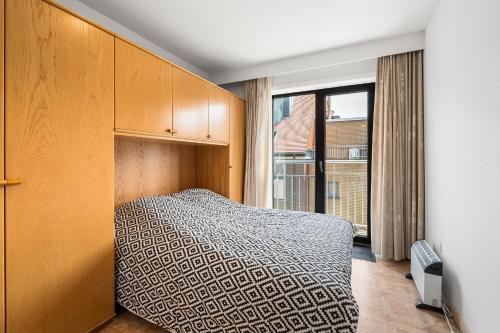 a bedroom with a bed and a large window at Lombardie 0502 in Nieuwpoort