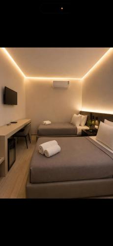 a hotel room with two beds and a desk and a television at tyty cairo hotel in Cairo