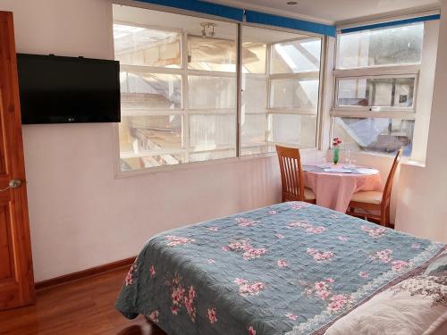 ein Schlafzimmer mit einem Bett, einem Fenster und einem Tisch in der Unterkunft Nubes Hotel in Viña del Mar