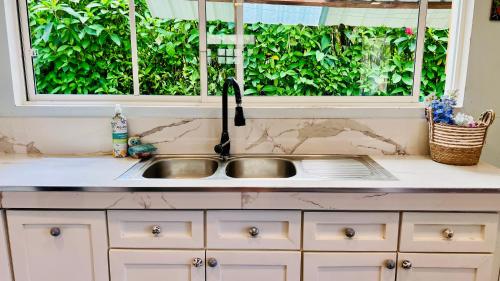 a kitchen sink in front of a window at Hermosa casa con aire acondicionado rodeada de aves y naturaleza incluye desayuno in Puyo