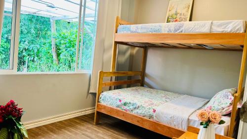 a bedroom with two bunk beds and a window at Hermosa casa con aire acondicionado rodeada de aves y naturaleza incluye desayuno in Puyo