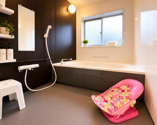 a bathroom with a bath tub and a childs chair at ParkView SAKURA in Aomori