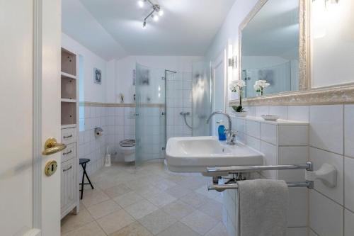 a white bathroom with a sink and a toilet at Villa-Magnolia-H in Hohwacht