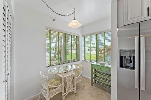 a kitchen with a table and chairs and windows at Spacious 2BR 2BA apartment close to the beach in Jupiter