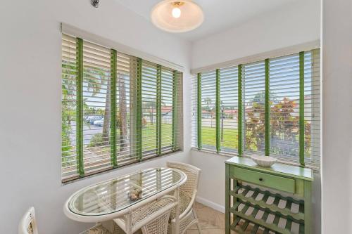 a room with a table and chairs and windows at Spacious 2BR 2BA apartment close to the beach in Jupiter
