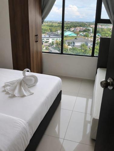 a bedroom with a white bed with a large window at CeeJay Suites in Penampang