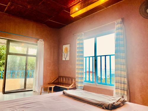 a bedroom with a bed and a large window at Confetti House in Quy Nhon