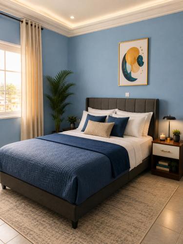 a bedroom with a large bed with blue walls at The Blue Resort in Yaoundé