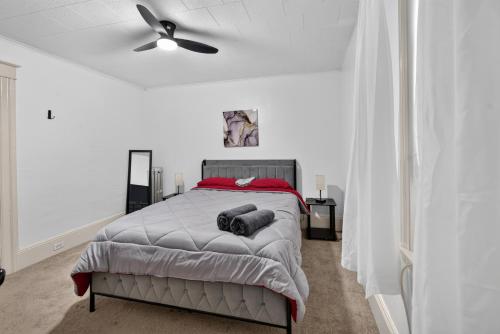 a white bedroom with a bed and a ceiling fan at Charming 2-Bedroom, 1-Bath Getaway in Carbondale