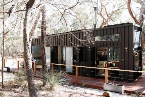 a black house in the woods with trees at SHAK Halls Gap - Off Grid Tiny Home in Halls Gap