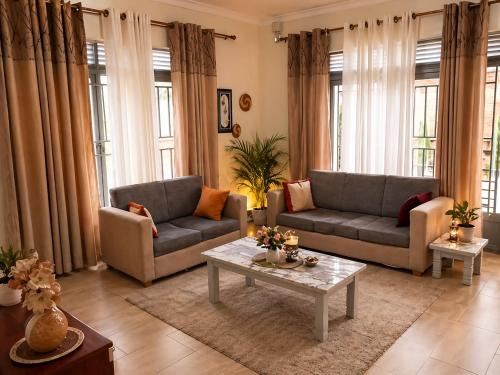 a living room with two couches and a coffee table at Maison De Omashi in Kigali