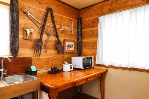 a kitchen counter with a sink and utensils on the wall at おきなわ民泊海族 in Okinawa City