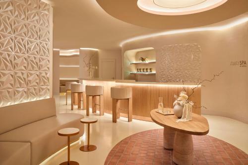 a restaurant with a bar with stools and a table at W Barcelona in Barcelona