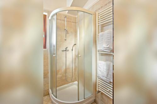 La salle de bains est pourvue d'une douche avec une porte en verre. dans l'établissement Turistična kmetija Štanfel, à Podsabotin