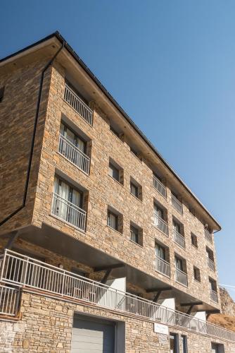 a brick building with balconies on the side of it at Pierre & Vacances Andorra Sunari Peretol in Bordes d´Envalira