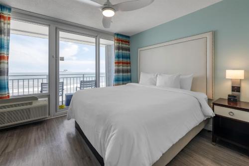 a bedroom with a large bed and a large window at Hilton Vacation Club Daytona Seabreeze Daytona Beach in Daytona Beach