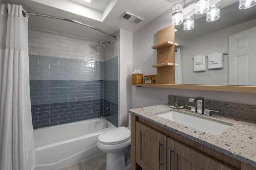 a bathroom with a sink and a toilet and a tub at Hilton Vacation Club Daytona Seabreeze Daytona Beach in Daytona Beach